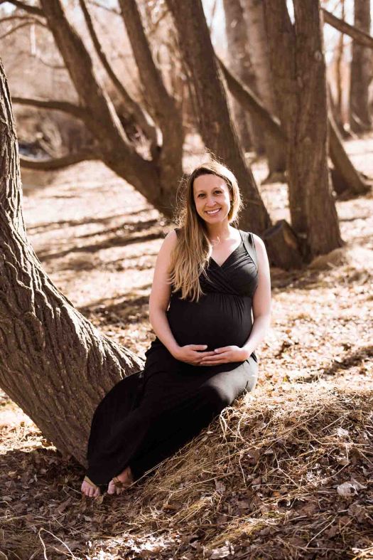 Calgary lifestyle photographer, maternity photos at Confederation Park, family in front of trees