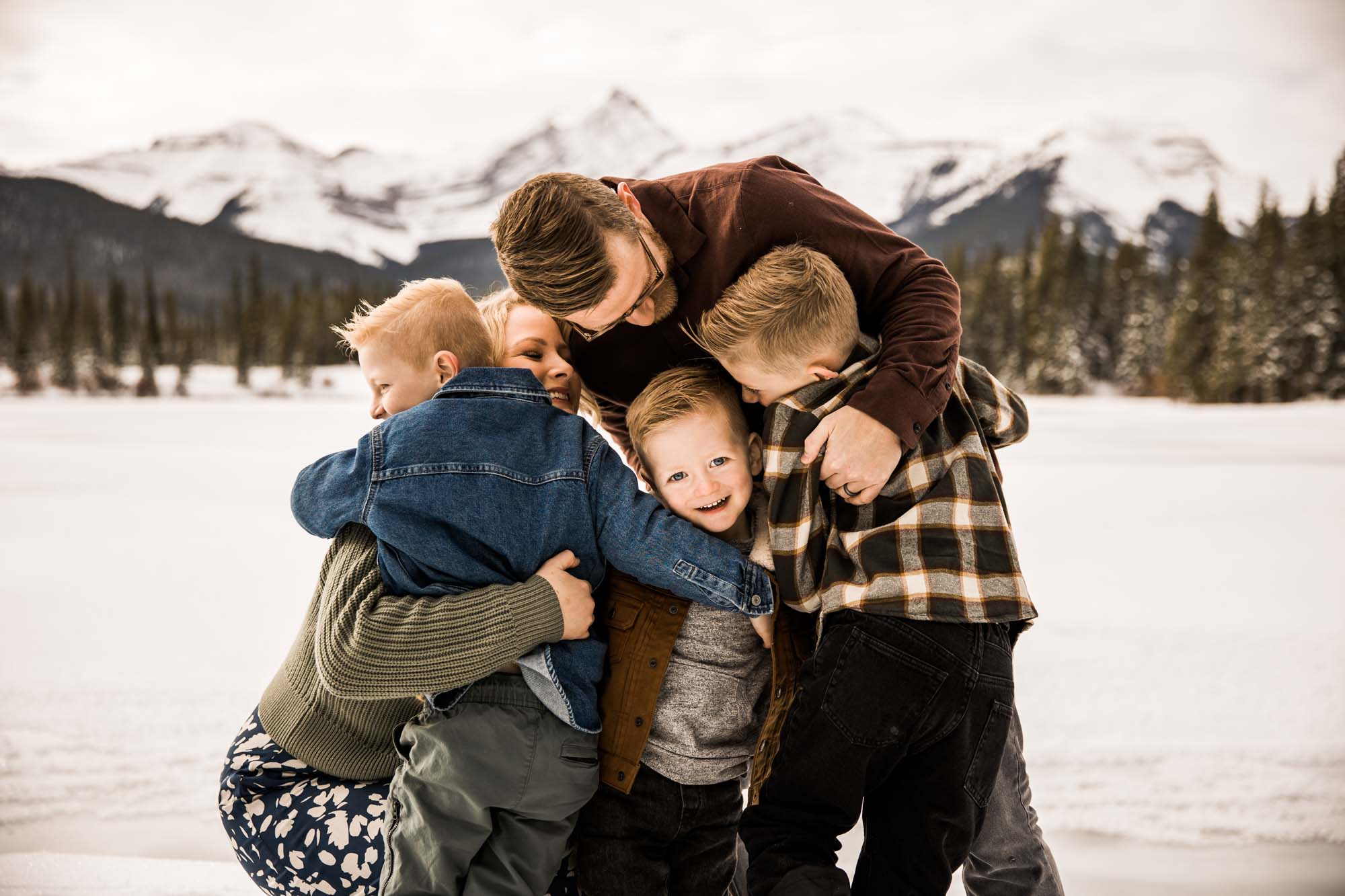Calgary, Banff, Kananaskis Country lifestyle family photographer, family playing in the snow in the mountains during their photoshoot